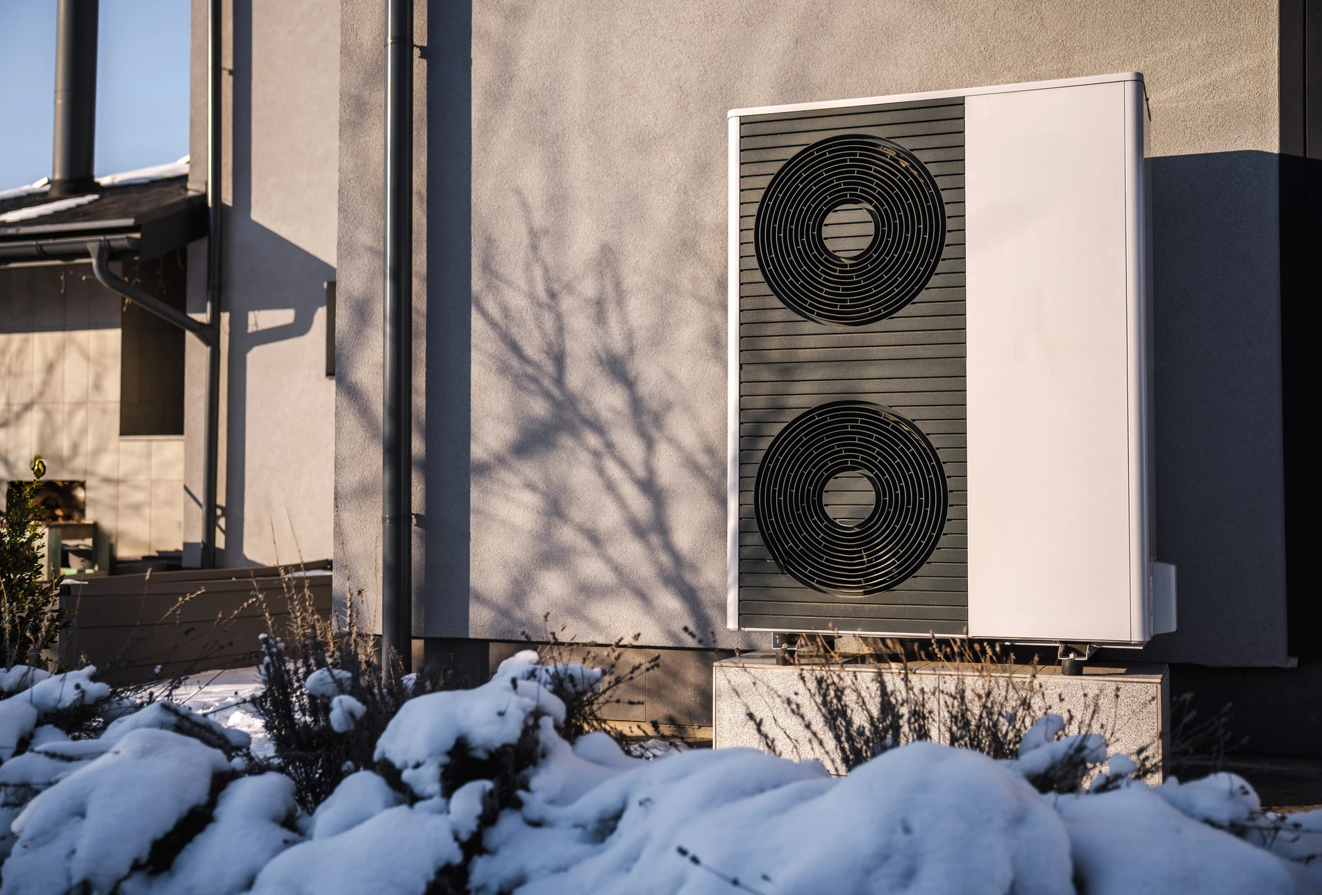 Plombier professionnel en combinaison bleue et gants de protection bleus travaillant sur raccords de plomberie