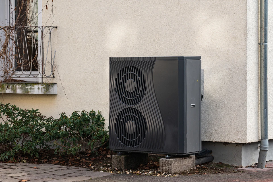 Extérieur d'un bâtiment avec mur turquoise et conduit gris vertical