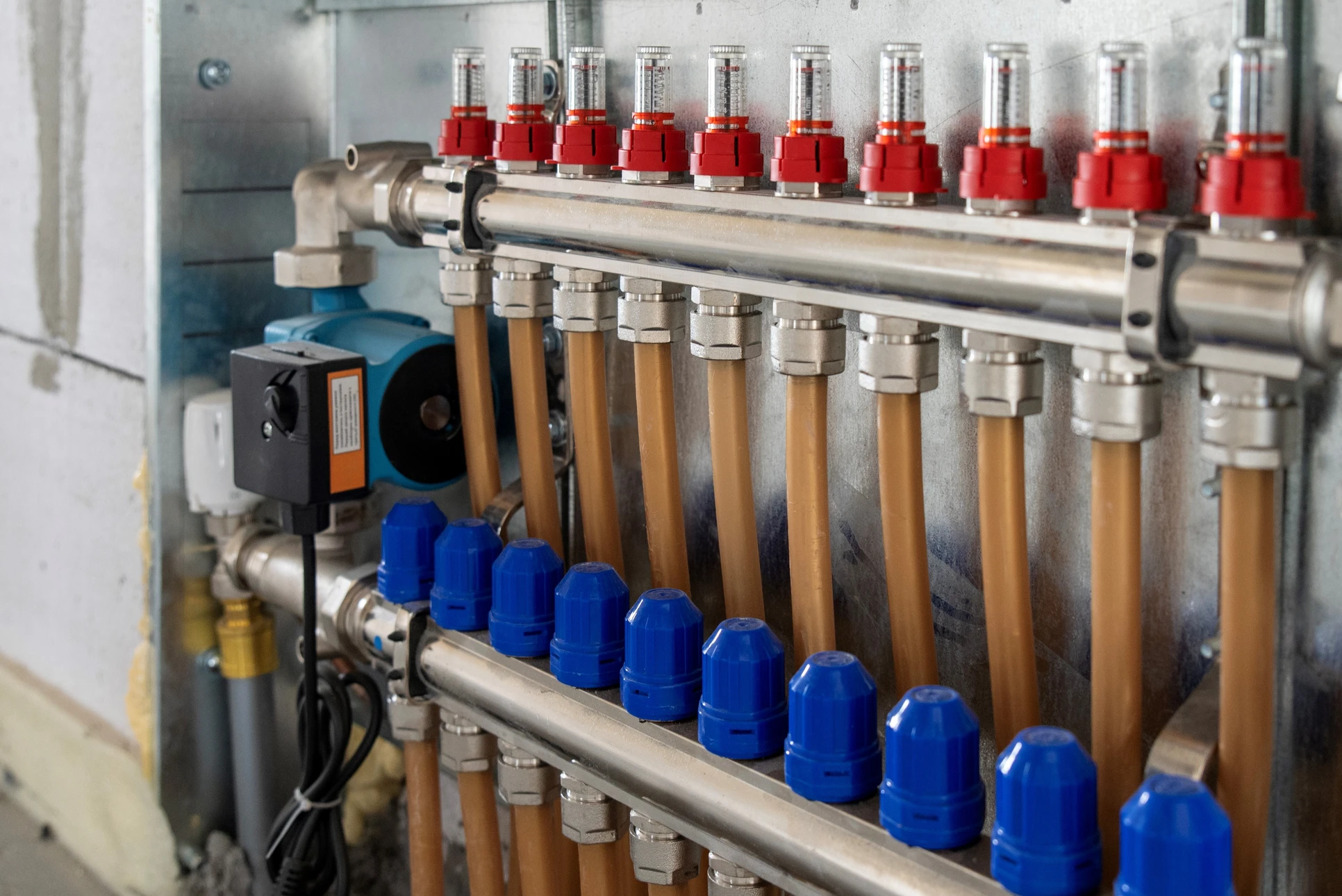 Intérieur d'un bâtiment en construction ou rénovation avec quatre tuyaux en cuivre vertical traversant le plafond